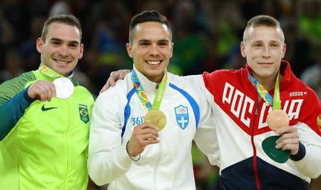 2016 Rio Olympics - Artistic Gymnastics - Victory Ceremony - Men's Rings Victory Ceremony - Rio Olympic Arena - Rio de Janeiro, Brazil - 15/08/2016. Gold medalist Eleftherios Petrounias (GRE) of Greece, silver medalist Arthur Zanetti (BRA) of Brazil and bronze medalist Denis Abliazin (RUS) of Russia pose with their medals. REUTERS/Mike Blake