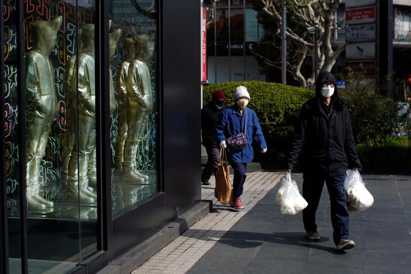 People wearing masks are seen at a shopping mall in downtown Shanghai