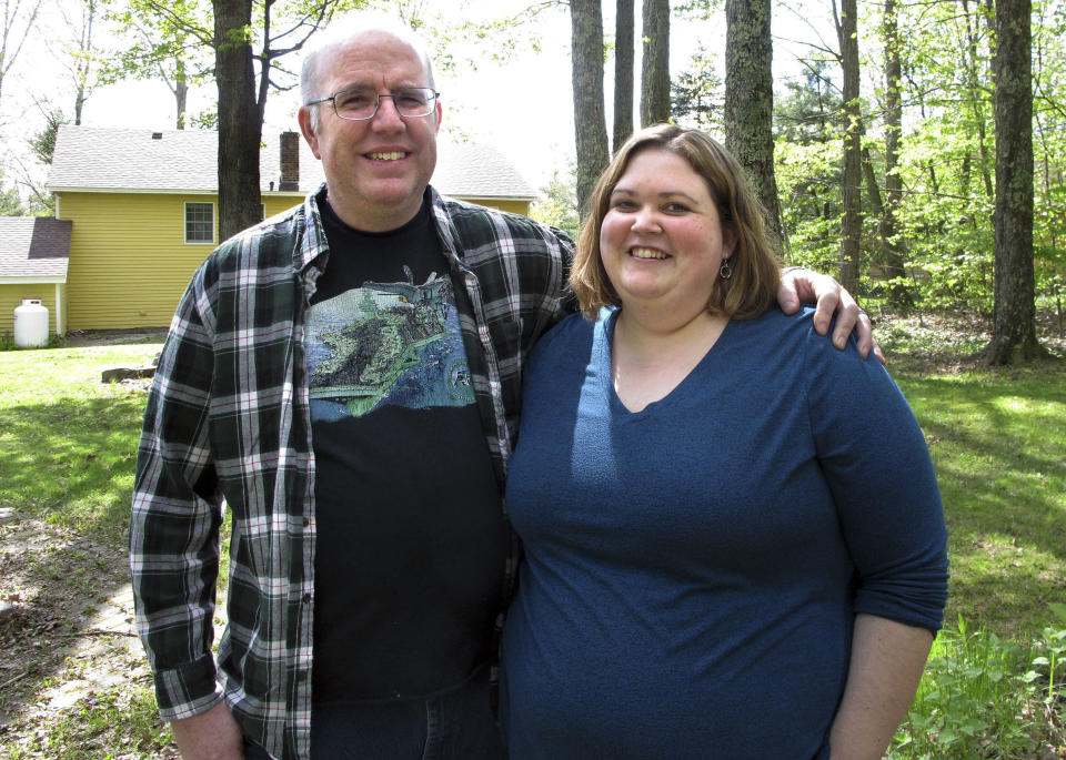 In this May 15, 2019, photo, Jonathan and Beth Dow stand in their backyard in Bennington, Vt. The couple recently moved to Vermont from Colorado through a Vermont program to attract new residents. (AP Photo/Lisa Rathke)