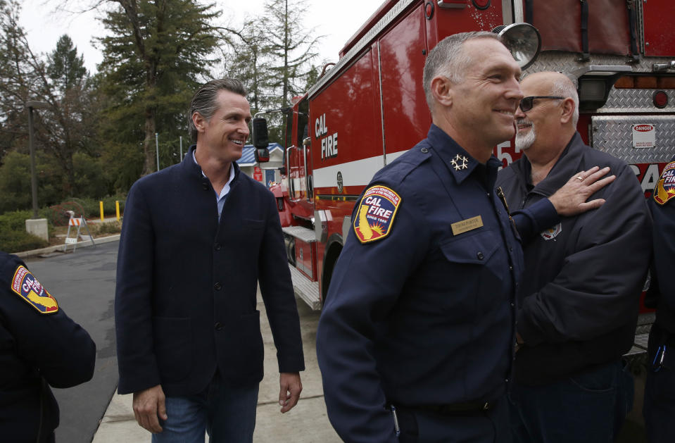 Gov. Gavin Newsom, left, is escorted by Thom Porter, right, to the California Department of Forestry and Fire Protection CalFire Colfax Station Tuesday, Jan. 8, 2019, in Colfax, Calif. On his first full day as governor, Newsom announced executive actions to improve the state's response to wildfires and other emergencies. Earlier Newsom appointed Porter, to head the state's firefighting agency. (AP Photo/Rich Pedroncelli)