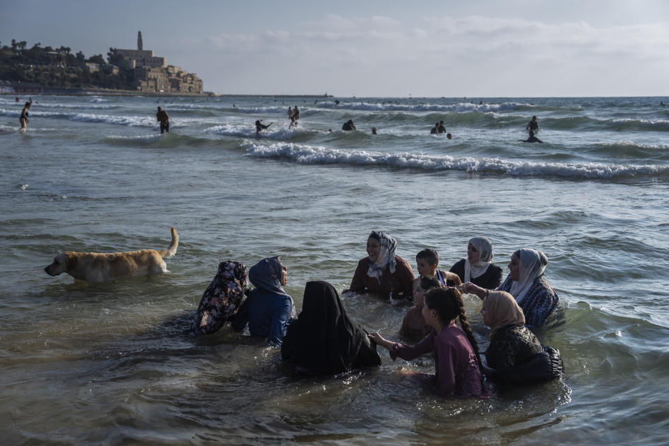 Palestinians enjoy the day at a dog-friendly beach during the Eid Al Adha festival in Tel Aviv, Israel, Saturday, July 1, 2023. (AP Photo/Oded Balilty)