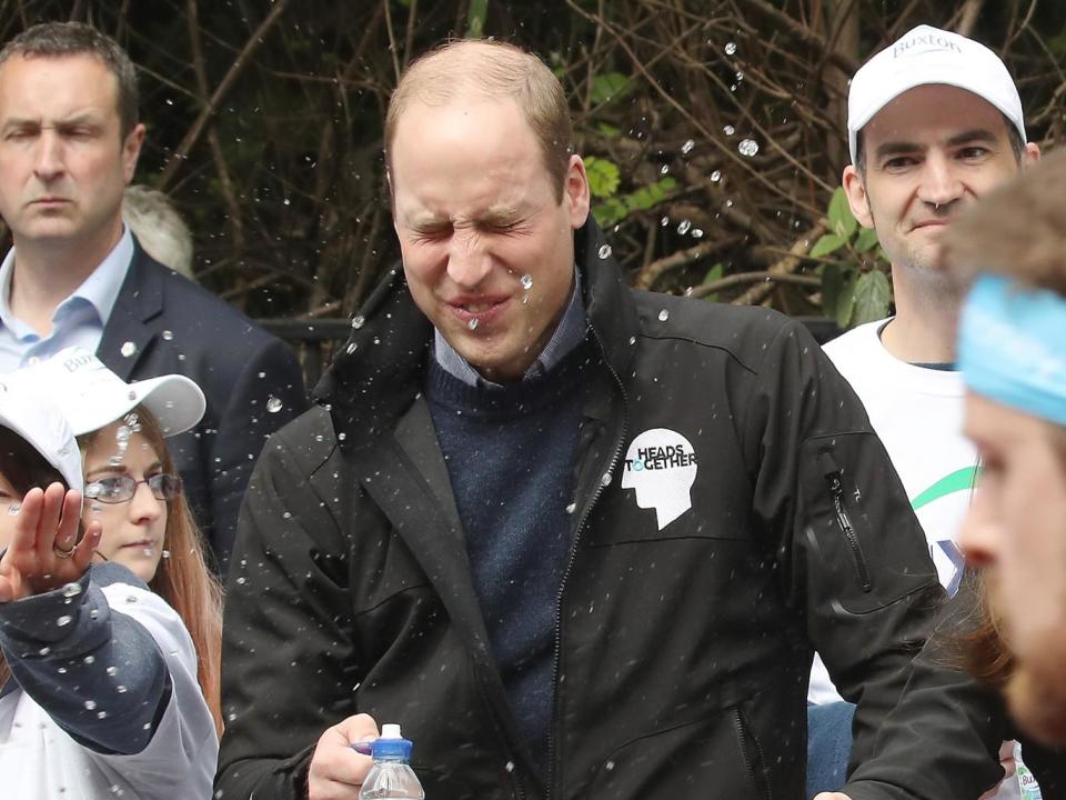 A runner squirts water towards Prince William, Duke of Cambridge as he hands out water to runners during the 2017 Virgin Money London Marathon (Getty Images)