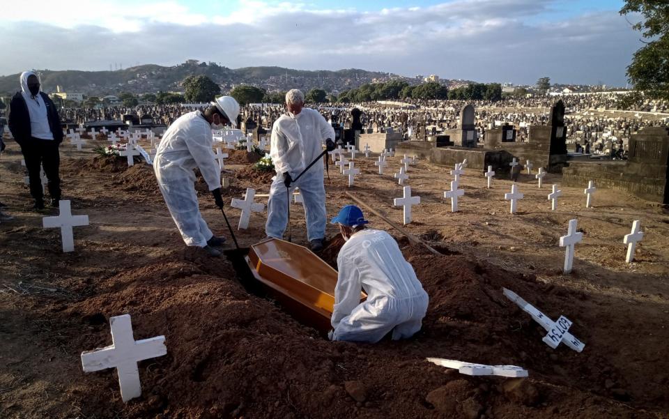 Funeral workers carry out burials of Covid-19 victims at Inhauma Cemetery, north of the city, in Rio de Janeiro, Brazil - Fabio Teixeira/Anadolu Agency