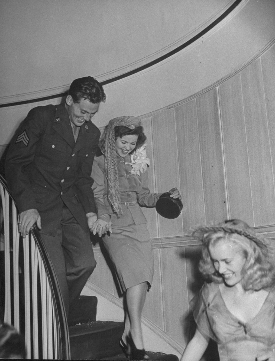 <p>After hosting a large reception in her Hollywood home, Shirley Temple traded her long-sleeve satin wedding gown for a grey belted suit, as she and her new husband, Army Sargent John Agar, departed for their honeymoon. The couple was all smiles as their friends and family sent them off as newlyweds. <br></p>