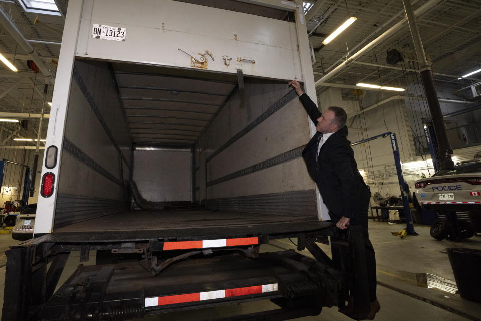 Police officers open the back of a recovered truck during a press conference regarding Project 24K a joint investigation into the theft of gold from Pearson International Airport, in Brampton, Ontario, on Wednesday, April 17, 2024. (Arlyn McAdorey/The Canadian Press via AP)