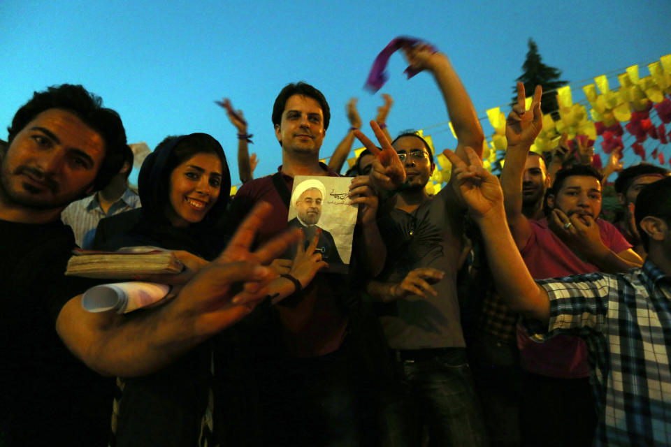 Iranians celebrate the victory of moderate presidential candidate Hassan Rouhani (portrait) in the Islamic Republic's presidential elections at Vanak Square, in northern Tehran, on June 15, 2013. (ATTA KENARE/AFP/Getty Images)