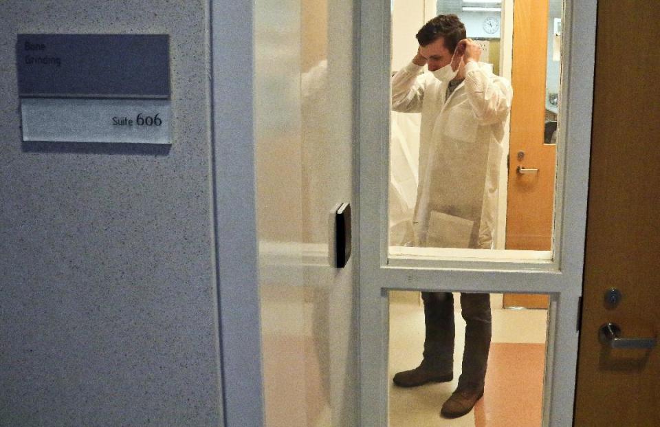 In this April 15, 2014 photo, Michael Mosco, a criminalist, prepares to enter the bone grinding room at the Office of Chief Medical Examiner in New York. The room is central to the examination of bone DNA from those who died on Sept. 11, 2001. Forensic scientists are still trying to match the bone with DNA from victims who have never been identified. (AP Photo/Bebeto Matthews)