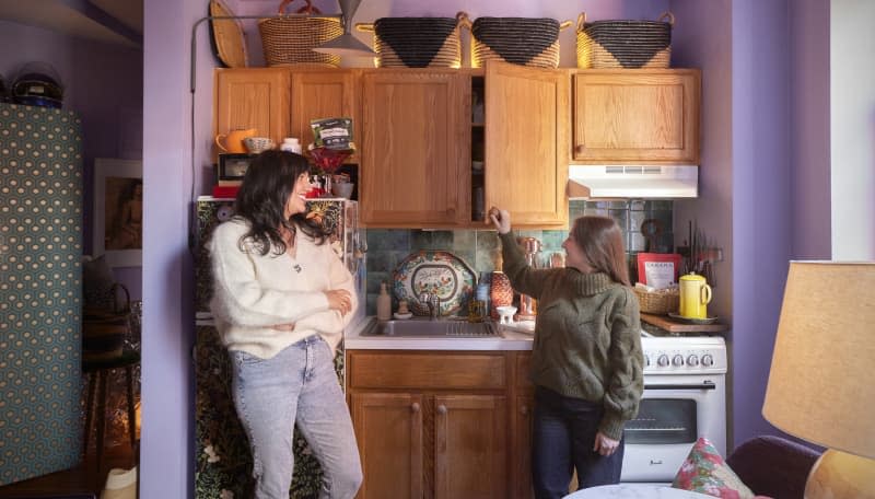 Dwellers standing in NYC apartment kitchen.