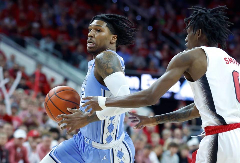 North Carolina’s Caleb Love (2) drives by N.C. State’s Terquavion Smith (0) during the first half of N.C. State’s game against UNC at PNC Arena in Raleigh, N.C., Sunday, Feb. 19, 2023. Ethan Hyman/ehyman@newsobserver.com