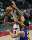 Detroit Pistons center Jahlil Okafor (13) is fouled by Denver Nuggets center JaVale McGee (34) during the second half of an NBA basketball game, Friday, May 14, 2021, in Detroit. (AP Photo/Carlos Osorio)