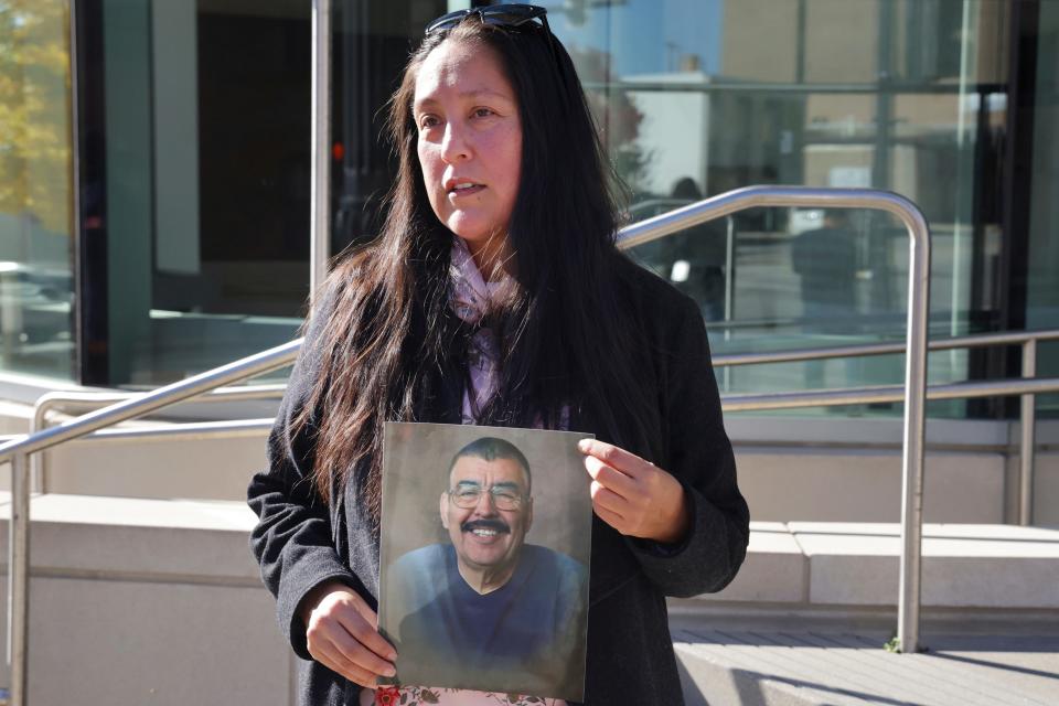 Ashbey Beasley holds a photo of murder victim Eduardo Uvaldo outside of the Lake County Courthouse following a hearing for Robert E. Crimo III, who is accused of murder in the Highland Park Fourth of July shootings, on Nov. 1, 2022, in Waukegan, Ill.