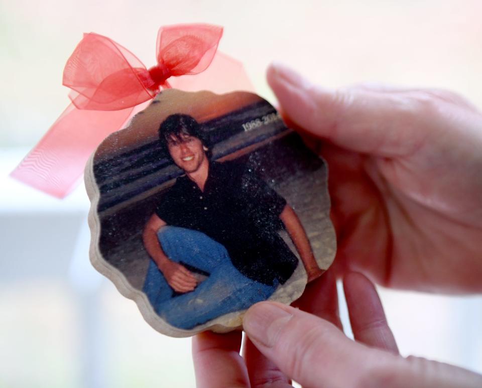 An ornament bears the image of Ryan Wozniak, who died in 2014. Michael and Amy Catlin Wozniak decorate a tree each year in Quail Hollow Park in Lake Township to honor Ryan's memory.