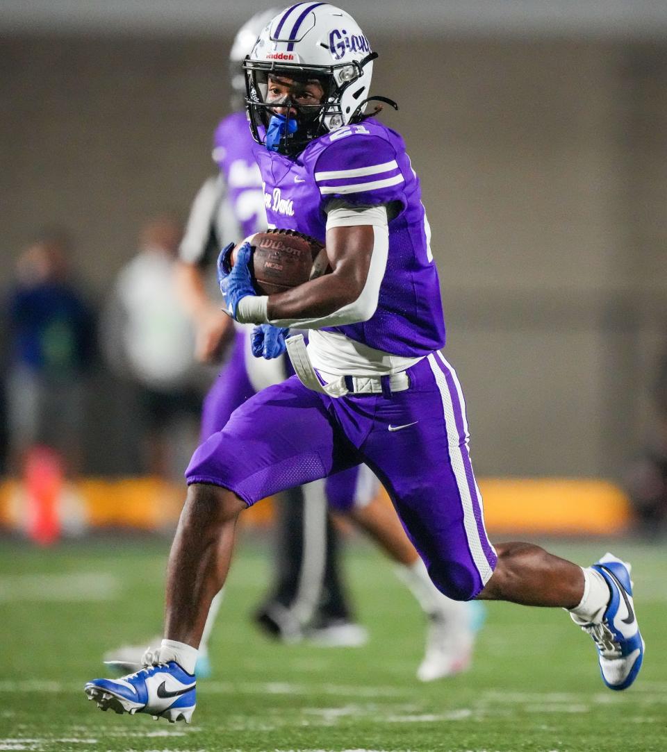 Ben Davis Giants running back Alijah Price (21) rushes up the field Friday, Oct. 27, 2023, during the game at Ben Davis High School in Indianapolis. The Ben Davis Giants defeated the Brownsburg Bulldogs, 28-25.