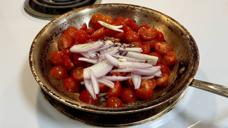 stainless steel skillet filled with tomatoes and shallots
