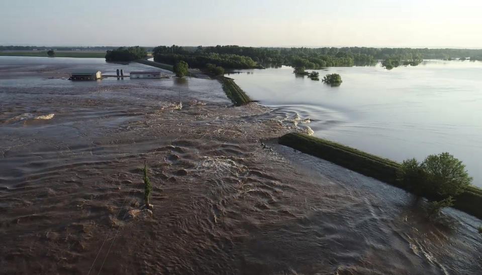 In this aerial image provided by Yell County Sheriff's Department water rushes through the levee along Arkansas River in Dardanelle, Ark., on Friday, May 31, 2019. Officials say the levee breached early Friday at Dardanelle, about 60 miles northwest of Little Rock. (Yell County Sheriff's Department via AP)