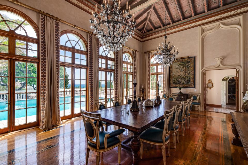 Large chandeliers decorate the formal dining room, which looks out at the pool.