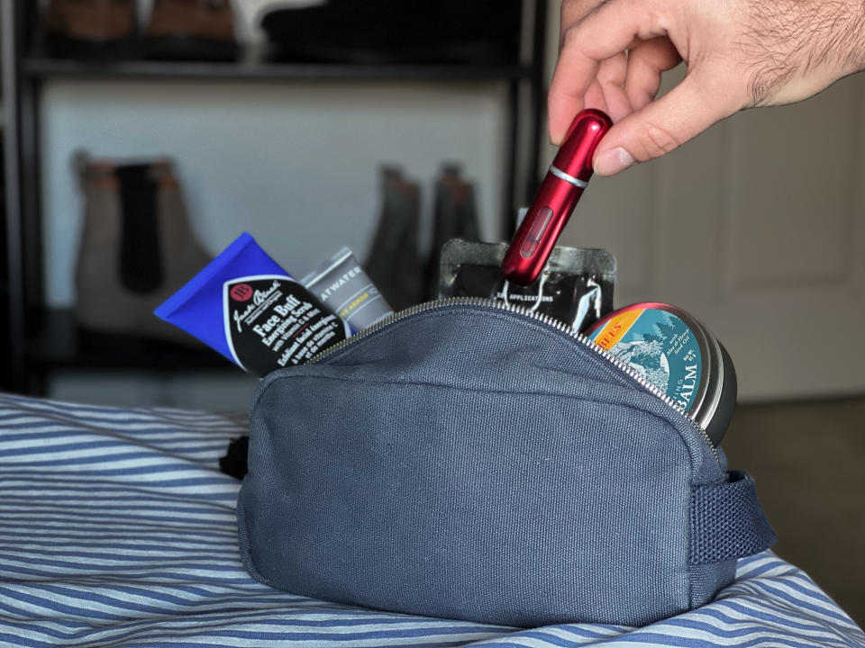 putting a red travalo atomizer in our toiletries bag before travel