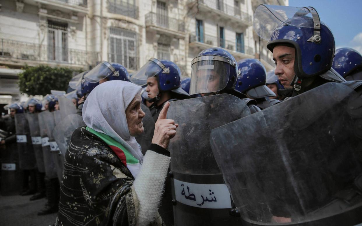 An elderly woman confronts security forces during a demonstration in Algiers, Algeria - AP