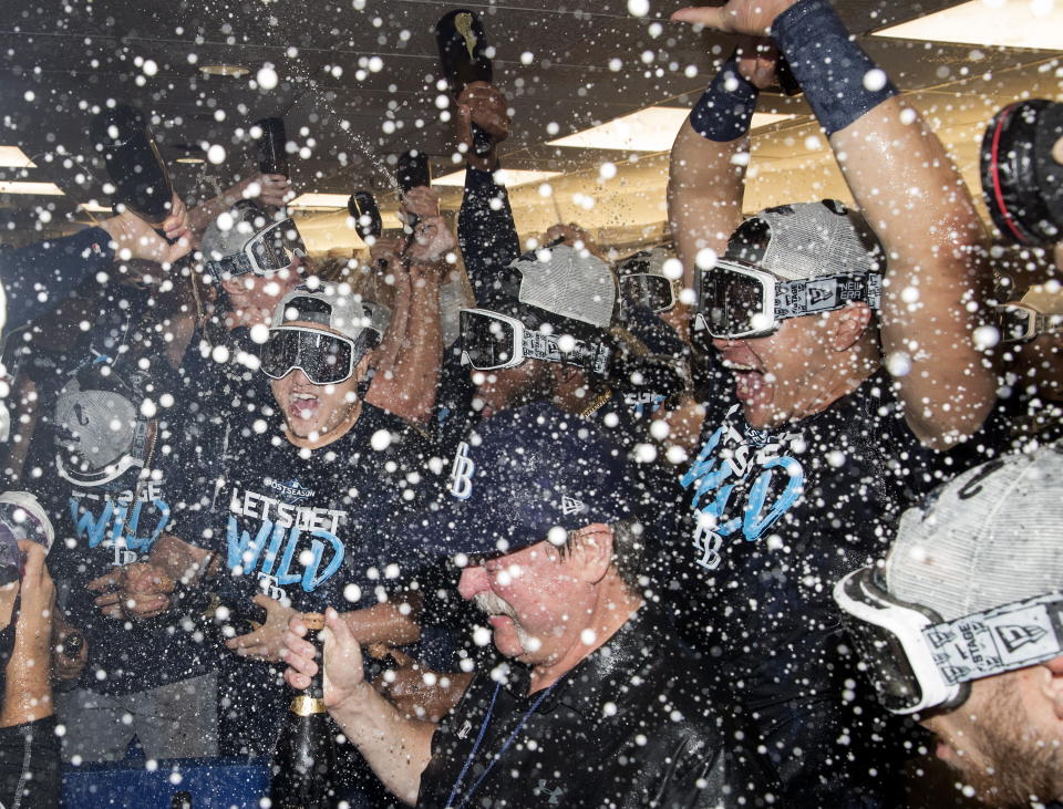 Tampa Bay Rays players celebrate in the clubhouse after they defeated the Toronto Blue Jays and clinched an MLB American League wild-card berth in Toronto, Friday, Sept. 27, 2019. (Fred Thornhill/The Canadian Press via AP)