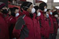 In this Tuesday, Feb. 18, 2020, photo, delivery workers for Chinese e-commerce giant JD.com prepare for the morning round of deliveries from a distribution center in Beijing, China. JD and rivals including Pinduoduo, Miss Fresh and Alibaba Group's Hema are scrambling to fill a boom in orders while protecting their employees. E-commerce is one of the few industries to thrive after anti-virus controls starting in late January closed factories, restaurants, cinemas, offices and shops nationwide and extinguished auto and real estate sales. (AP Photo/Ng Han Guan)