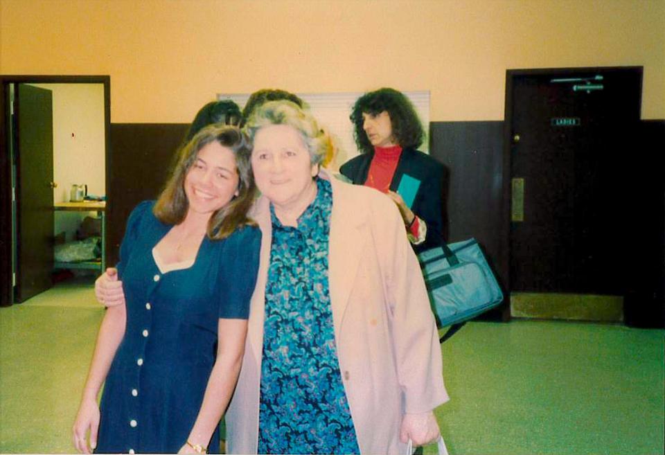 Nicole Johnson and her foster mother, Ester, standing inside a hallway and smiling.