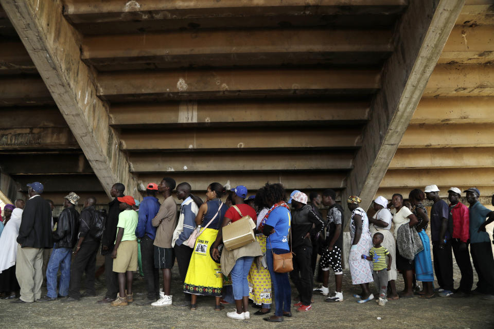 Mourners queue to pay their last respects at the coffin of former Zimbabwean President Robert Mugabe at the Rufaro Stadium in Harare, Friday, Sept. 13, 2019, where the body is on view at the stadium for a second day. Mugabe died last week in Singapore at the age of 95. He led the southern African nation for 37 years before being forced to resign in late 2017. (AP Photo/Themba Hadebe)