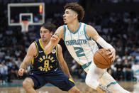 Charlotte Hornets guard LaMelo Ball (2) drives to the basket while guarded by Indiana Pacers guard T.J. McConnell (9) during the first half of an NBA basketball game in Charlotte, N.C., Wednesday, Oct. 20, 2021. (AP Photo/Jacob Kupferman)