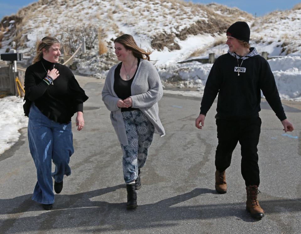 Aria Amos, 16, left, her sister Bella, 18 and brother Austin, 17 live together in a seasonal rental in Hampton after losing both parents within a year of each other. They walk from the sand dunes March 2, 2022. There is a GoFundMe set up to help the kids.