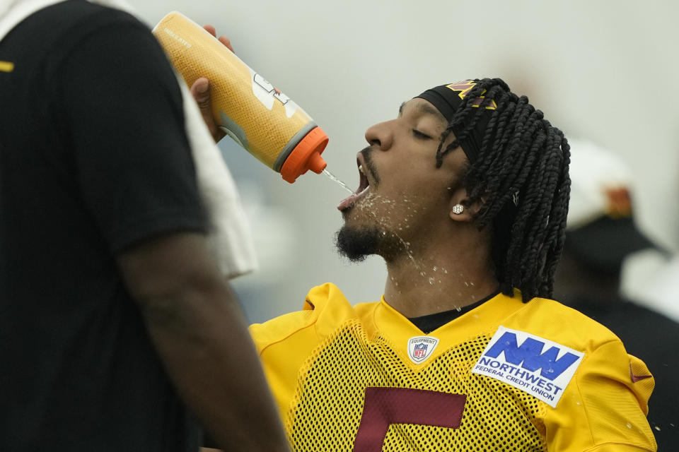 Washington Commanders first round draft pick quarterback Jayden Daniels gets water during an NFL rookie minicamp football practice in Ashburn, Va., Friday, May 10, 2024. (AP Photo/Susan Walsh)