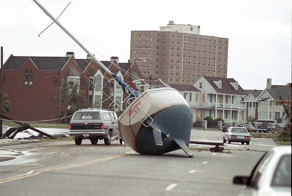 FILE- In this Sept. 22, 1989 file photo, a sailboat lies in the street of Charleston after it was washed ashore by Hurricane Hugo. From evacuating hundreds of thousands of people from the coast to live TV coverage in the shrieking wind and rain, 1989's Hurricane Hugo might have been the first U.S. storm of the modern age. (AP Photo/Lou Krasky, File)