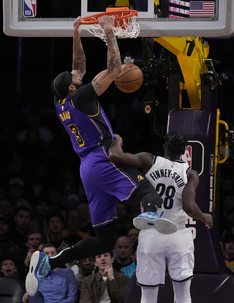 Los Angeles Lakers forward Anthony Davis (3) dunks against Brooklyn Nets forward Dorian Finney-Smith (28) during the first half of an NBA basketball game in Los Angeles, Friday, Jan. 19, 2024. (AP Photo/Ashley Landis)