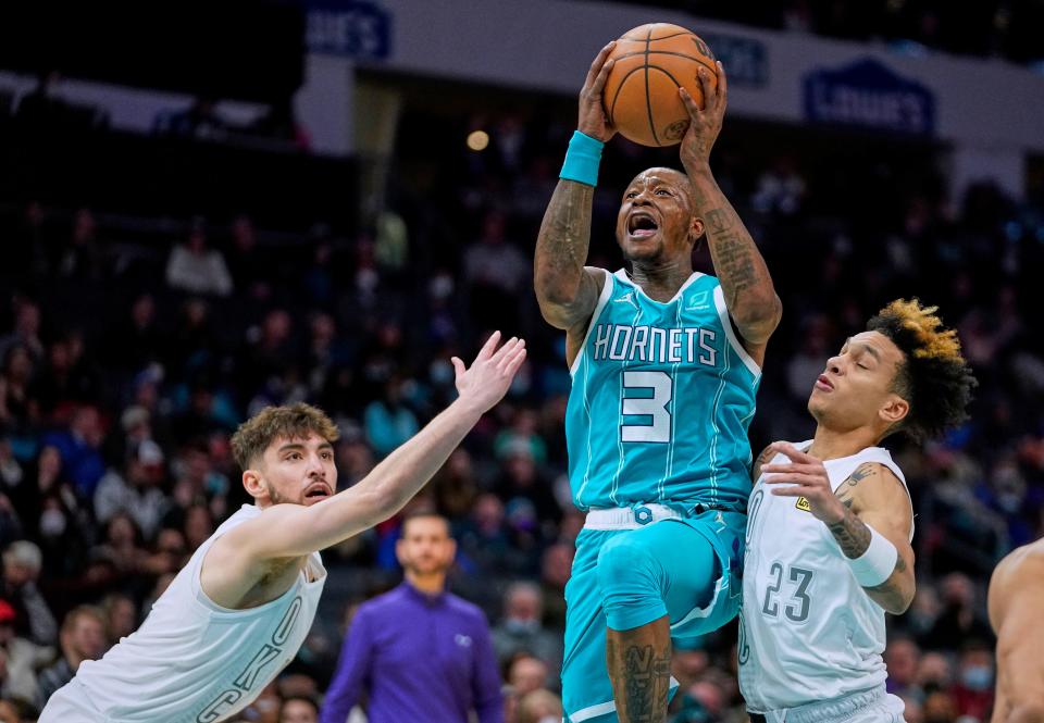 Hornets guard Terry Rozier (3) drives to the basket between Thunder guards Ty Jerome, left, and Tre Mann (23) during the first half Friday.