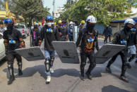 Anti-coup protesters with makeshift shields walk to take positions in Mandalay, Myanmar, Tuesday, March 9, 2021. Demonstrators in Myanmar's biggest city came out Monday night for their first mass protests in defiance of an 8 p.m. curfew, seeking to show support for an estimated 200 students trapped by security forces in a small area of one neighborhood. (AP Photo)