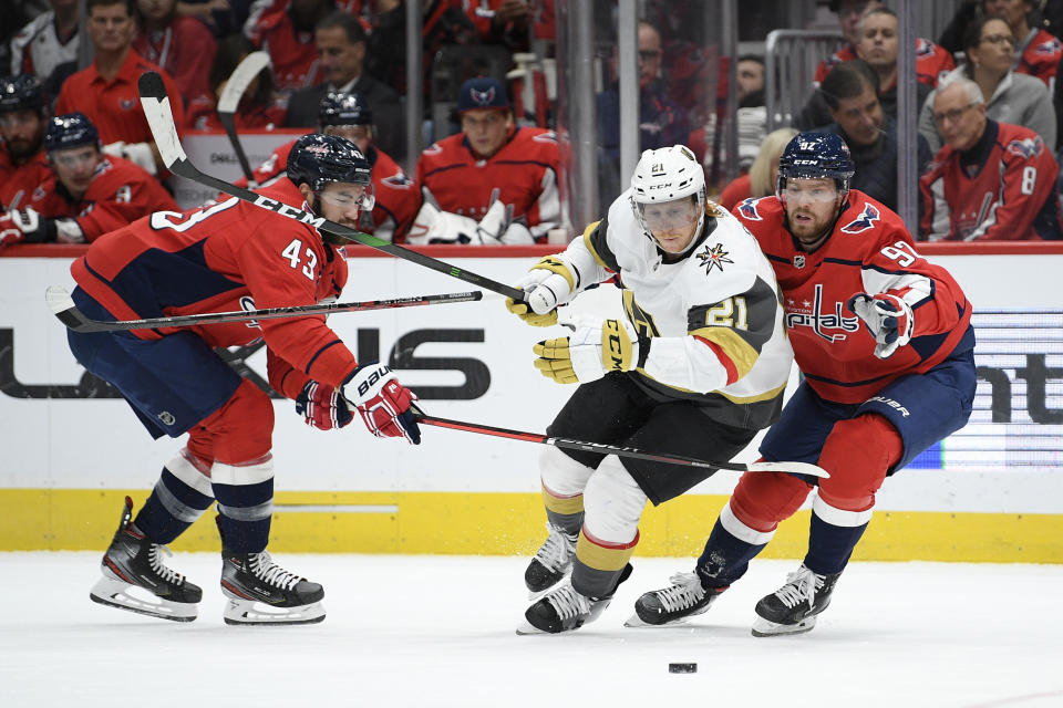 Vegas Golden Knights center Cody Eakin (21) battles for the puck against Washington Capitals right wing Tom Wilson (43) and center Evgeny Kuznetsov (92), of Russia, during the first period of an NHL hockey game, Saturday, Nov. 9, 2019, in Washington. (AP Photo/Nick Wass)