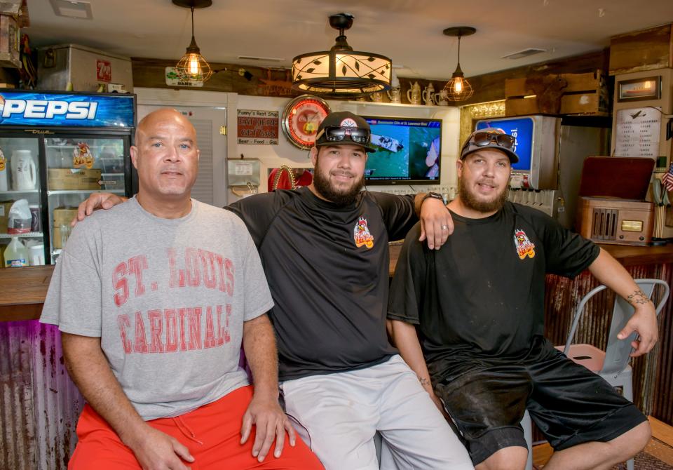 Kelly Petersen, left, and his sons Kelly Jr., middle, and Kyle opened their new restaurant KP's Wings and Fries in Hanna City on July 15.