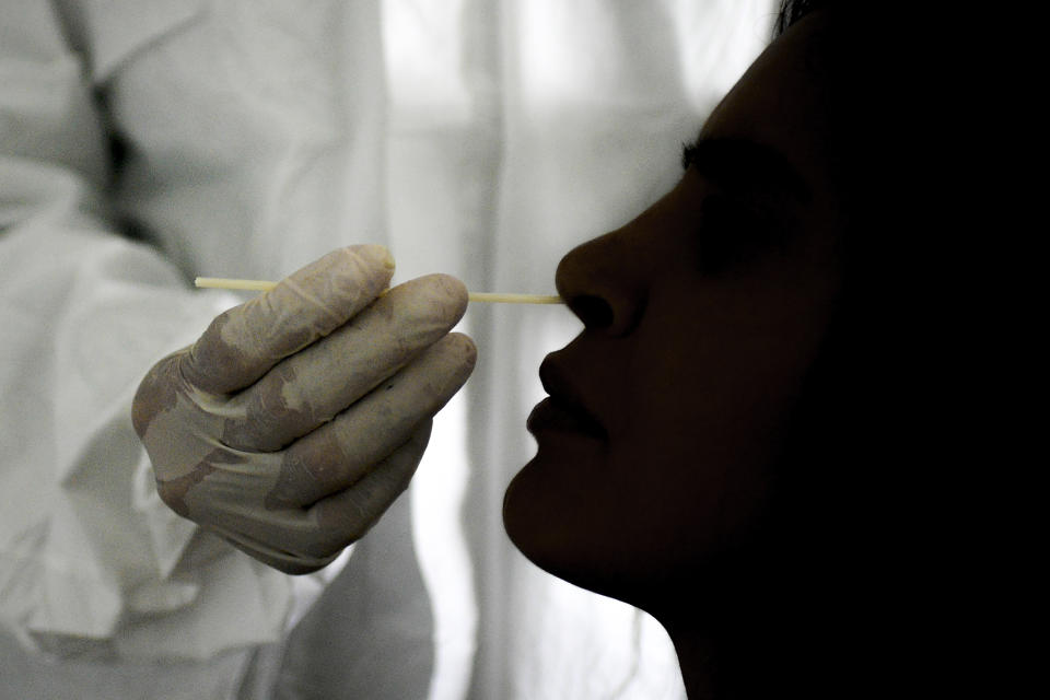 A doctor takes a nasal swab sample to test for COVID-19 at the Cocodrilos Sports Park in Caracas, Venezuela, Saturday, Sept. 19, 2020, amid the new coronavirus pandemic. (AP Photo/Matias Delacroix)