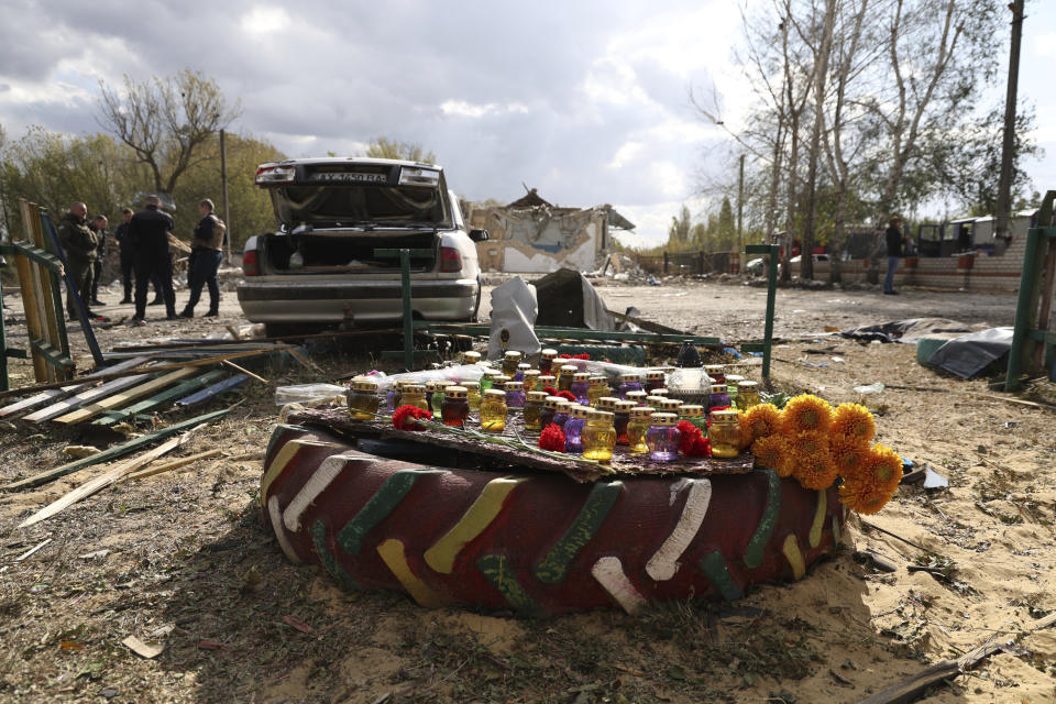 A memorial made with candles and flowers, which were brought by local residents lies in the village of Hroza near Kharkiv, Ukraine, Friday, Oct. 6, 2023. Ukrainian officials say at least 51 civilians were killed in a Russian rocket strike on a village store and cafe in the eastern part of the country in one of the deadliest attacks in recent months. (AP Photo/Alex Babenko)