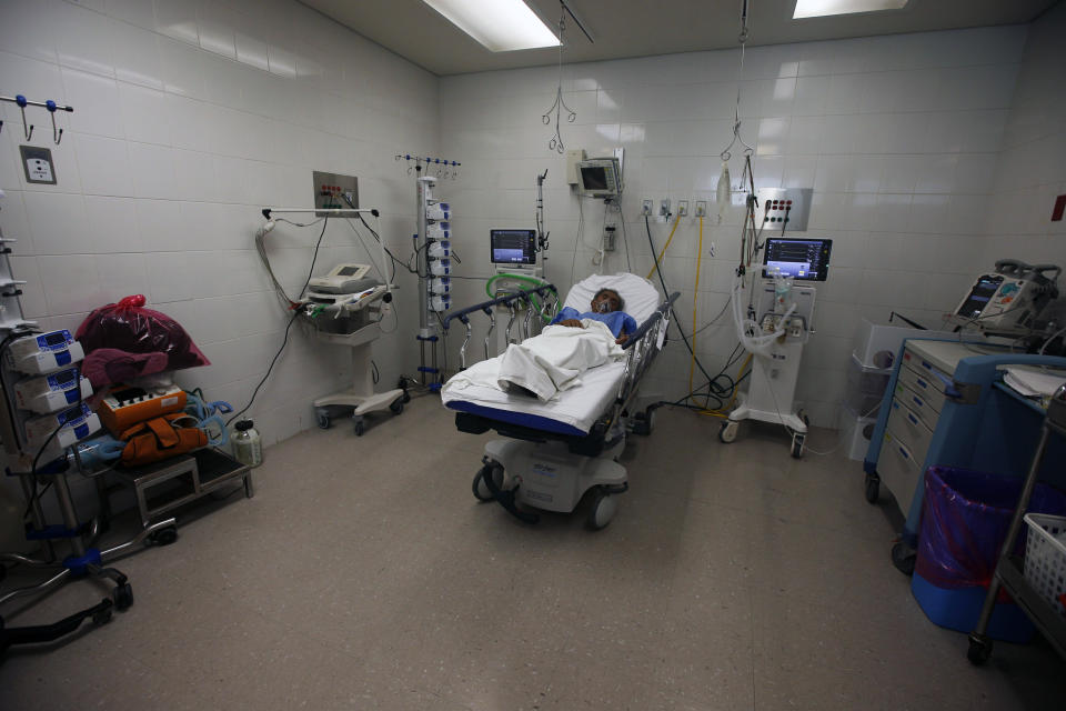 A patient that has just tested positive for COVID-19 sits on a bed of the emergency room in the Mexico City Ajusco Medio General Hospital, Wednesday, Dec. 2. 2020. Mexico continues to report an increase in the number of coronavirus cases, with Mexico City continuing to report the biggest portion of the surge. (AP Photo/Marco Ugarte)