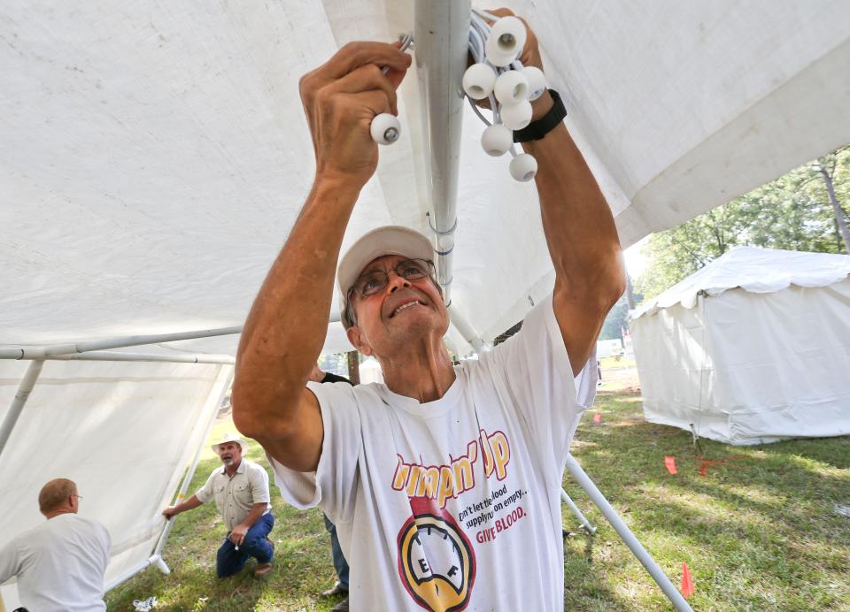 Tom Walker helps set up the Woodworkers Association of West Alabama booth as they prepare for the Kentuck Festival of the Arts at Kentuck Park in Northport Friday, Oct. 19, 2018. [Staff Photo/Gary Cosby Jr.]