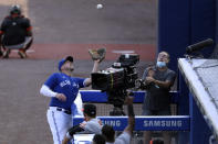 Toronto Blue Jays first baseman Travis Shaw, left, catches a foul ball hit by a Baltimore Orioles batter during the sixth inning of a baseball game, Sunday, Sept. 27, 2020, in Buffalo, N.Y. (AP Photo/Jeffrey T. Barnes)