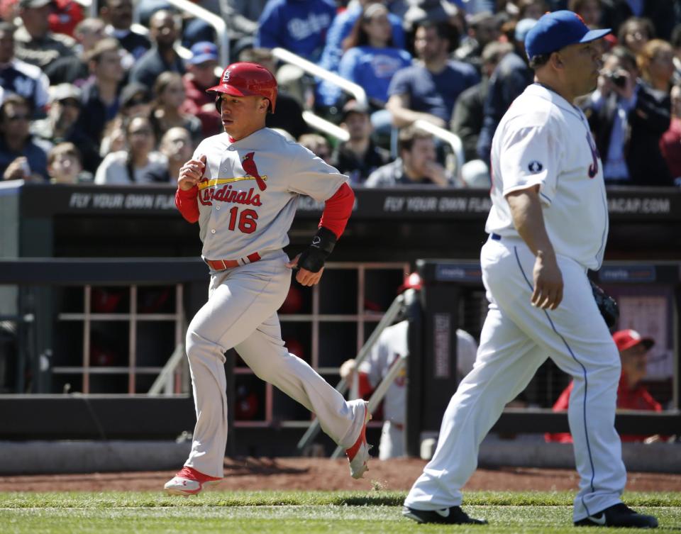 St. Louis Cardinals' Kolten Wong (16) runs past New York Mets starting pitcher Bartolo Colon as he scores on Tony Cruz's fifth-inning RBI double in a baseball game in New York, Thursday, April 24, 2014. (AP Photo/Kathy Willens)