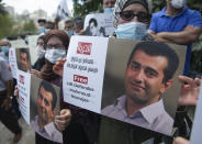 Palestinians carry posters showing Mahmoud Nawajaa, a leading coordinator of the Palestinian-led boycott movement against Israel, BDS, during a protest calling for the EU to press for his release, in front of the German Representative Office, in the West Bank city of Ramallah, Tuesday, Aug. 11, 2020. The activist was arrested on July 30, remains in Israeli custody and has not been charged. Israel says the arrest is not connected to his boycott activities, and that he is is suspected of unspecified “security offenses," but boycott activists accuse Israel of fabricating the case in order to justify the arrest. (AP Photo/Nasser Nasser)