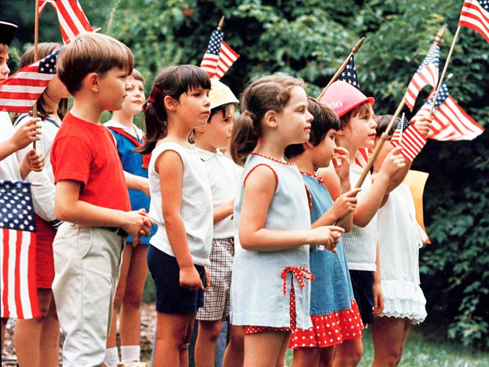 Children holding flags celebrate the US Bicentennial on July 4, 1976.