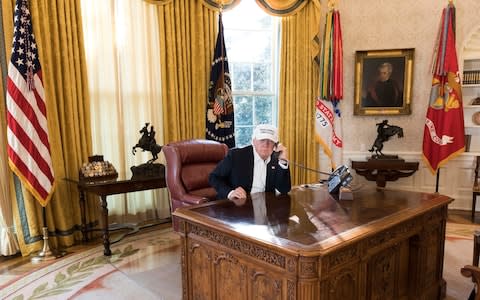 President Donald Trump talks on the phone in the Oval Office during negotiations to end the Democrats government shutdown - Credit: White House