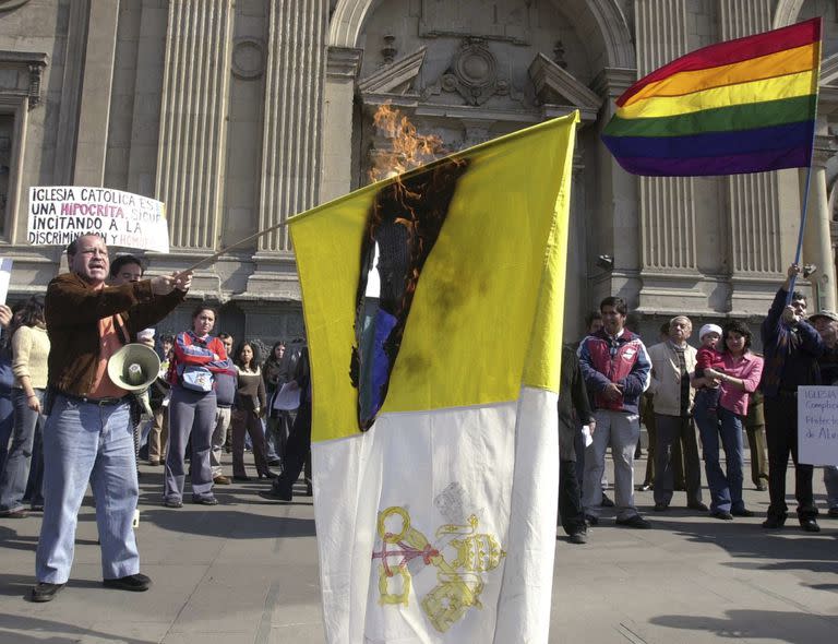 Rolando Jiménez, líder de una organización chilena de derechos de los homosexuales, sostiene una bandera del Vaticano en llamas durante una protesta de activistas homosexuales contra el rechazo de la Iglesia Católica Romana a los matrimonios del mismo sexo, frente a una catedral en Santiago, Chile, en esta foto de archivo del viernes 15 de agosto de 2003.