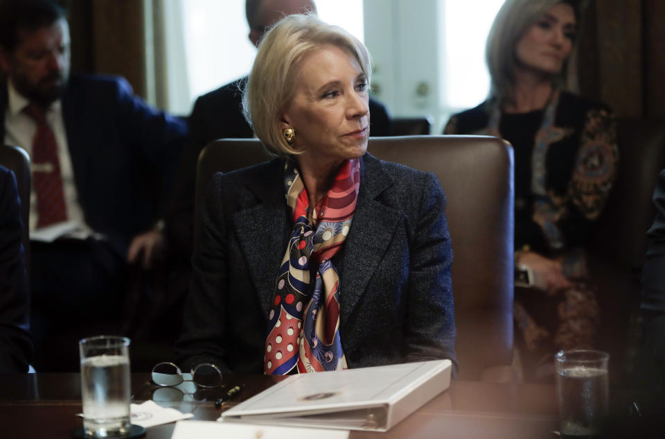 FILE - In this Oct. 21, 2019, file photo, Education Secretary Betsy DeVos listening to President Donald Trump during a Cabinet meeting in the Cabinet Room of the White House in Washington. DeVos is calling on Congress to consider splitting her department’s financial aid operation into a separate federal agency with the flexibility to operate like a private bank. (AP Photo/Pablo Martinez Monsivais, File)