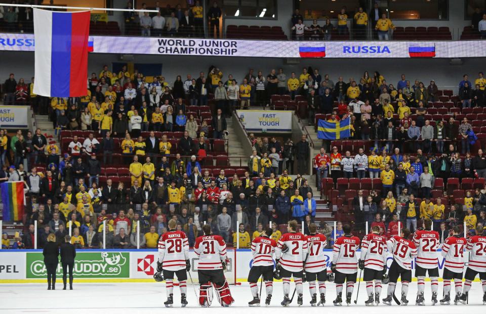 Members of Canada watch the Russian flag being raised after Russia won the bronze medal following their IIHF World Junior Championship ice hockey game in Malmo, Sweden, January 5, 2014. REUTERS/Alexander Demianchuk (SWEDEN - Tags: SPORT ICE HOCKEY)