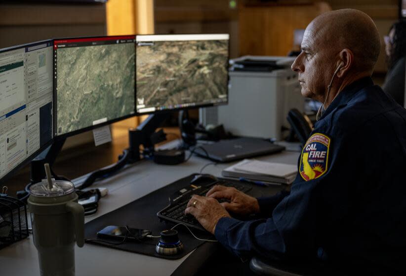 MORENO VALLEY, CA - AUGUST 9, 2023: Cal Fire Ted Schaffer monitors computer screens which depicts views of wildfire camera systems in real time throughout the state of California at the Southern California Geographic Area Coordination Center on August 9, 2023 in Moreno Valley, CA. The agency is using AI to help monitor the camera systems.(Gina Ferazzi / Los Angeles Times)