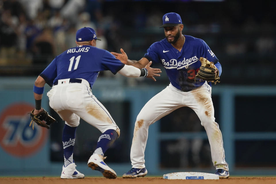 Los Angeles Dodgers second baseman Amed Rosario (31) celebrates with shortstop Miguel Rojas (11) after the team's win in the second baseball game of a doubleheader against the Miami Marlins, Saturday, Aug. 19, 2023, in Los Angeles. (AP Photo/Ryan Sun)