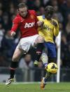Manchester United's Wayne Rooney (L) challenges Arsenal's Bacary Sagna during their English Premier League soccer match at Old Trafford in Manchester, northern England, November 10, 2013.